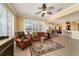 Spacious living room with a view into kitchen, large windows, comfortable seating and ceiling fan at 9443 Sw 71St Loop, Ocala, FL 34481