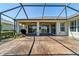 Large screened patio with decorative landscaping and ceiling fans, offering a tranquil outdoor space at 9443 Sw 71St Loop, Ocala, FL 34481