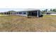 Backyard featuring a well-maintained lawn and view of the home's screened in lanai, perfect for outdoor activities at 9973 Sw 107Th Ter, Ocala, FL 34481