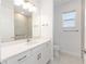 Modern bathroom features a white vanity, neutral tile, and a well-lit mirror, creating a clean and bright space at 9973 Sw 107Th Ter, Ocala, FL 34481