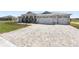 Paver driveway leads to a three-car garage enhancing the curb appeal of this modern home at 9973 Sw 107Th Ter, Ocala, FL 34481