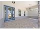 Covered front porch with beautiful stone pillars, patterned pavers, and stylish exterior lighting at 9973 Sw 107Th Ter, Ocala, FL 34481