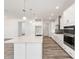 Bright kitchen with white cabinets, a large island with quartz countertops, and stainless-steel appliances at 9973 Sw 107Th Ter, Ocala, FL 34481