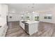 Modern kitchen features a central island with sink, stainless steel appliances and wood-look floors at 9973 Sw 107Th Ter, Ocala, FL 34481