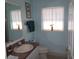 Bright bathroom with a sink, toilet, and window for natural light, with light blue walls at 11653 Sw 72Nd Cir, Ocala, FL 34476