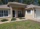 Inviting front entrance with a brick walkway, manicured bushes, and a cozy bench at 11653 Sw 72Nd Cir, Ocala, FL 34476