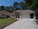 Well-maintained single-story home with neutral colors, a spacious driveway, and attached two-car garage at 11653 Sw 72Nd Cir, Ocala, FL 34476