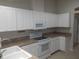 Bright kitchen with white cabinets, counters, and appliances at 11653 Sw 72Nd Cir, Ocala, FL 34476