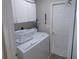 Functional laundry room featuring a washer, dryer, and built-in storage cabinets at 11653 Sw 72Nd Cir, Ocala, FL 34476