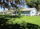 Well-maintained backyard with mature trees, lush green grass, and a chain link fence at 12002 Sw 137Th Loop, Dunnellon, FL 34432