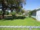 Lush backyard with mature trees providing shade, a chain link fence, and well-maintained lawn at 12002 Sw 137Th Loop, Dunnellon, FL 34432