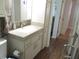 Bright bathroom featuring a vanity with a stone countertop, a modern faucet, and storage cabinets at 12002 Sw 137Th Loop, Dunnellon, FL 34432