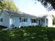Well-maintained home featuring blue siding, shutters, and a lush front lawn at 12002 Sw 137Th Loop, Dunnellon, FL 34432