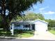 Charming single-story home with light blue siding, blue shutters, and mature trees at 12002 Sw 137Th Loop, Dunnellon, FL 34432