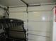 White garage door adjacent to a golf cart and providing secure access to the garage space at 12002 Sw 137Th Loop, Dunnellon, FL 34432