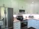 Bright kitchen features stainless steel appliances, white cabinets, and modern countertops at 12002 Sw 137Th Loop, Dunnellon, FL 34432