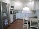 Bright kitchen featuring stainless steel appliances, white cabinetry, and an adjacent breakfast nook at 12002 Sw 137Th Loop, Dunnellon, FL 34432