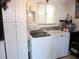 Bright laundry room with white washer and dryer, cabinets, and a window providing natural light at 12002 Sw 137Th Loop, Dunnellon, FL 34432