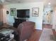 View of living room featuring TV, comfortable furniture, and an open doorway to adjacent area at 12002 Sw 137Th Loop, Dunnellon, FL 34432
