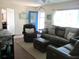 Comfortable living room with leather furniture, bright door, ceiling fan, and ample natural light at 12002 Sw 137Th Loop, Dunnellon, FL 34432