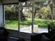 The screened patio offers ample light and a view of a large backyard with mature trees at 12002 Sw 137Th Loop, Dunnellon, FL 34432