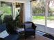 Enclosed porch featuring comfortable seating and a view of the green backyard at 12002 Sw 137Th Loop, Dunnellon, FL 34432