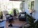 Relaxing sunroom with comfortable wicker furniture and a view of lush landscaping at 12002 Sw 137Th Loop, Dunnellon, FL 34432