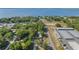 A high-angle shot displays the home's location relative to the lake, other houses, and a long storage warehouse at 12351 Se Hwy 464, Ocklawaha, FL 32179