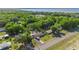 An aerial view of the property showcases its proximity to lush trees and views of a tranquil lake at 12351 Se Hwy 464, Ocklawaha, FL 32179