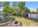 Large, grassy backyard featuring a fire pit, storage shed, and privacy fence at 12351 Se Hwy 464, Ocklawaha, FL 32179