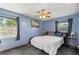 This blue bedroom features a ceiling fan, two windows, a bed, and decor creating a relaxing space at 12351 Se Hwy 464, Ocklawaha, FL 32179