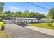 Wide shot of a single story home with solar panels, carport, and extended driveway at 12351 Se Hwy 464, Ocklawaha, FL 32179