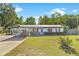 Charming single story home with solar panels, inviting curb appeal, and a spacious front yard at 12351 Se Hwy 464, Ocklawaha, FL 32179