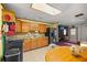 Sunlit kitchen boasts warm wood cabinets, skylight, tile floor, and modern appliances, open to the living space at 12351 Se Hwy 464, Ocklawaha, FL 32179