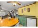Cozy kitchen with a wooden table and chairs, a unique clock and a counter with a modern dishwasher at 12351 Se Hwy 464, Ocklawaha, FL 32179