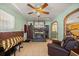 Comfortable living room featuring a stone fireplace, tiled floors, and ample seating at 12351 Se Hwy 464, Ocklawaha, FL 32179