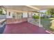 Covered porch with decorative brick accents and a railing, offering a cozy outdoor space at 12351 Se Hwy 464, Ocklawaha, FL 32179