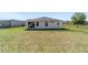 Back view of the home showcasing the screen porch with a spacious lawn and fenced in yard at 13423 Sw 48Th Ave, Ocala, FL 34473