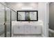 Modern bathroom featuring dual sinks, undermount lights, vanity, large framed mirror, and glass shower doors at 13423 Sw 48Th Ave, Ocala, FL 34473