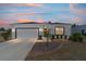 Charming single-story home featuring a well-manicured front yard, a two-car garage, at twilight at 13423 Sw 48Th Ave, Ocala, FL 34473