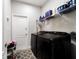A laundry room featuring black washer and dryer, wire rack, and tile flooring for efficient chores at 13423 Sw 48Th Ave, Ocala, FL 34473