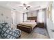 This bedroom features a tray ceiling, ceiling fan and a large wooden bed frame on grey wood floors at 13423 Sw 48Th Ave, Ocala, FL 34473