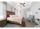 This bedroom features a tray ceiling, ceiling fan and a large wooden bed frame on grey wood floors at 13423 Sw 48Th Ave, Ocala, FL 34473