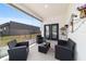 Covered patio area with sleek black outdoor furniture overlooking the grassy backyard at 13423 Sw 48Th Ave, Ocala, FL 34473