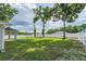 Large grassy backyard surrounded by mature trees and a white vinyl privacy fence at 13588 Se 102Nd Ct, Belleview, FL 34420