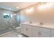Modern bathroom with dual sinks, white cabinets, and a walk-in shower with glass doors and tiled walls at 13588 Se 102Nd Ct, Belleview, FL 34420