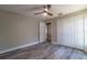 This bedroom features a ceiling fan, wood-look floors and a double door closet at 13588 Se 102Nd Ct, Belleview, FL 34420