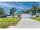 Inviting single-story home with a well-kept lawn, an attached garage, and a mix of stone and siding accents at 13588 Se 102Nd Ct, Belleview, FL 34420
