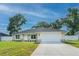 Charming single-story home with a well-manicured lawn, attached two-car garage, and a mix of stone and siding accents at 13588 Se 102Nd Ct, Belleview, FL 34420