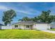 Single-story home with a manicured lawn, an attached garage, and a combination of stone and siding accents at 13588 Se 102Nd Ct, Belleview, FL 34420